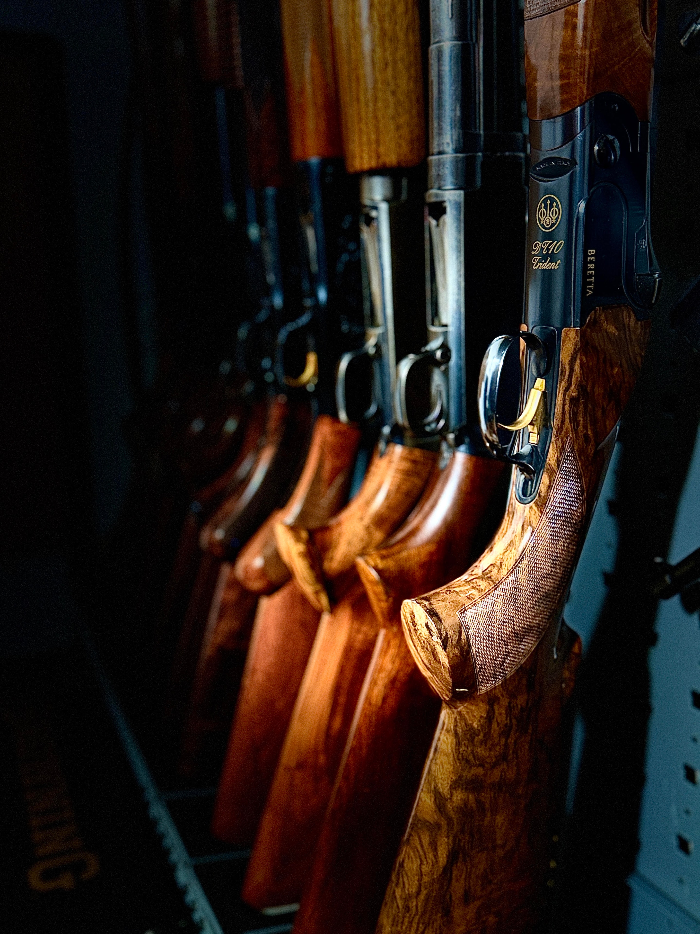 Collection of fine shotguns including a Beretta DT10 Trident with figured walnut stocks racked in the Northwoods Firearms gun safe