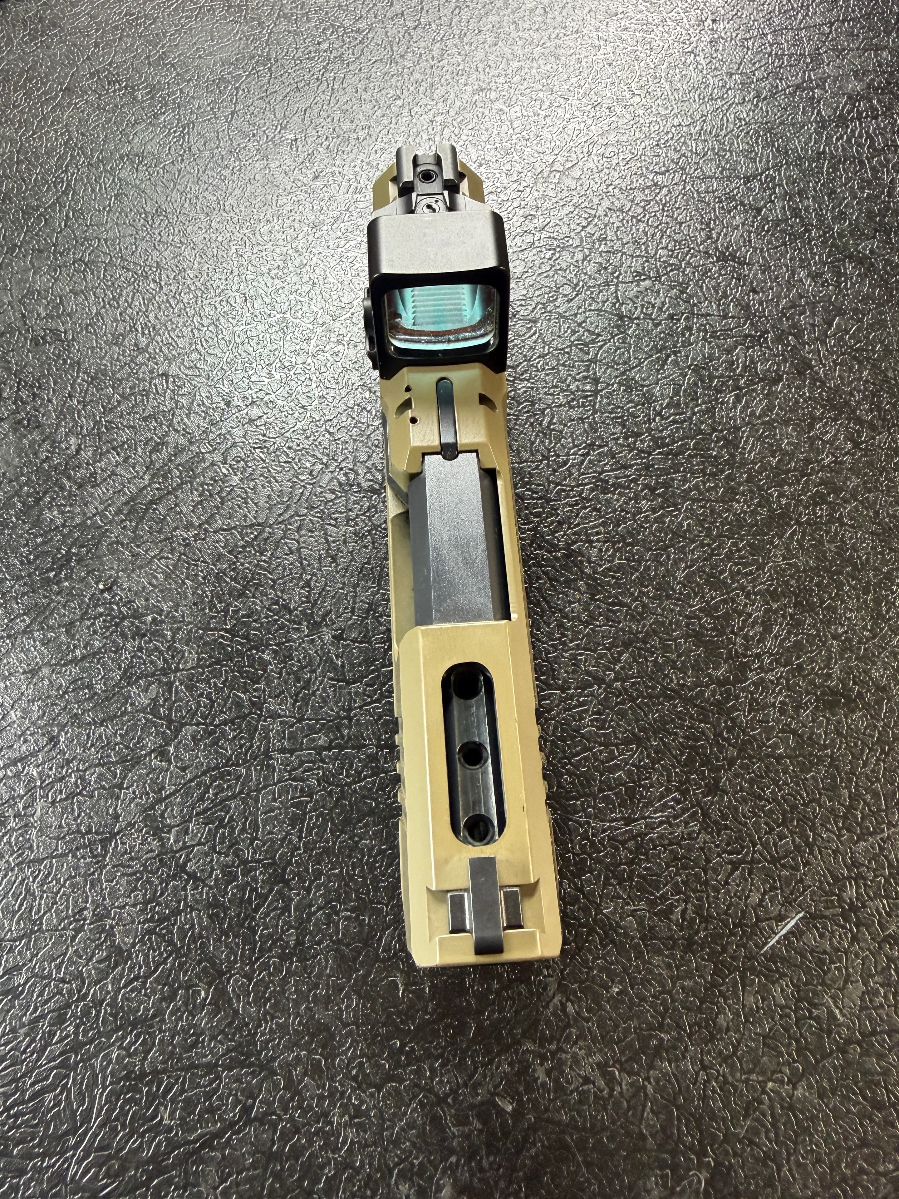 FDE pistol slide with optic cut milled and Holosun red dot installed — top-down detail showing precision machining work by Northwoods Firearms, Crandon, WI
