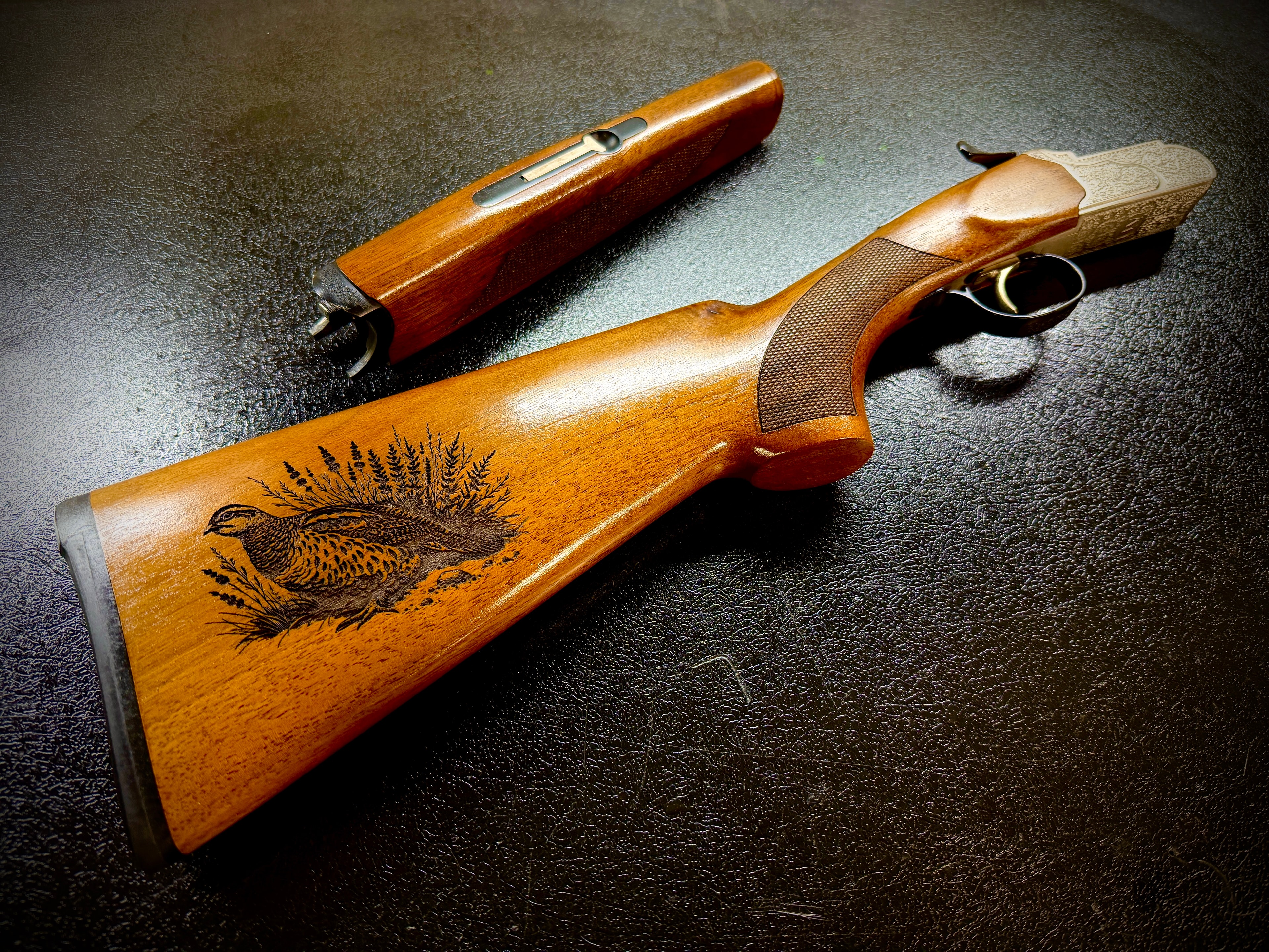 Laser-engraved quail and brush scene on walnut shotgun stock by Northwoods Firearms, Crandon, WI