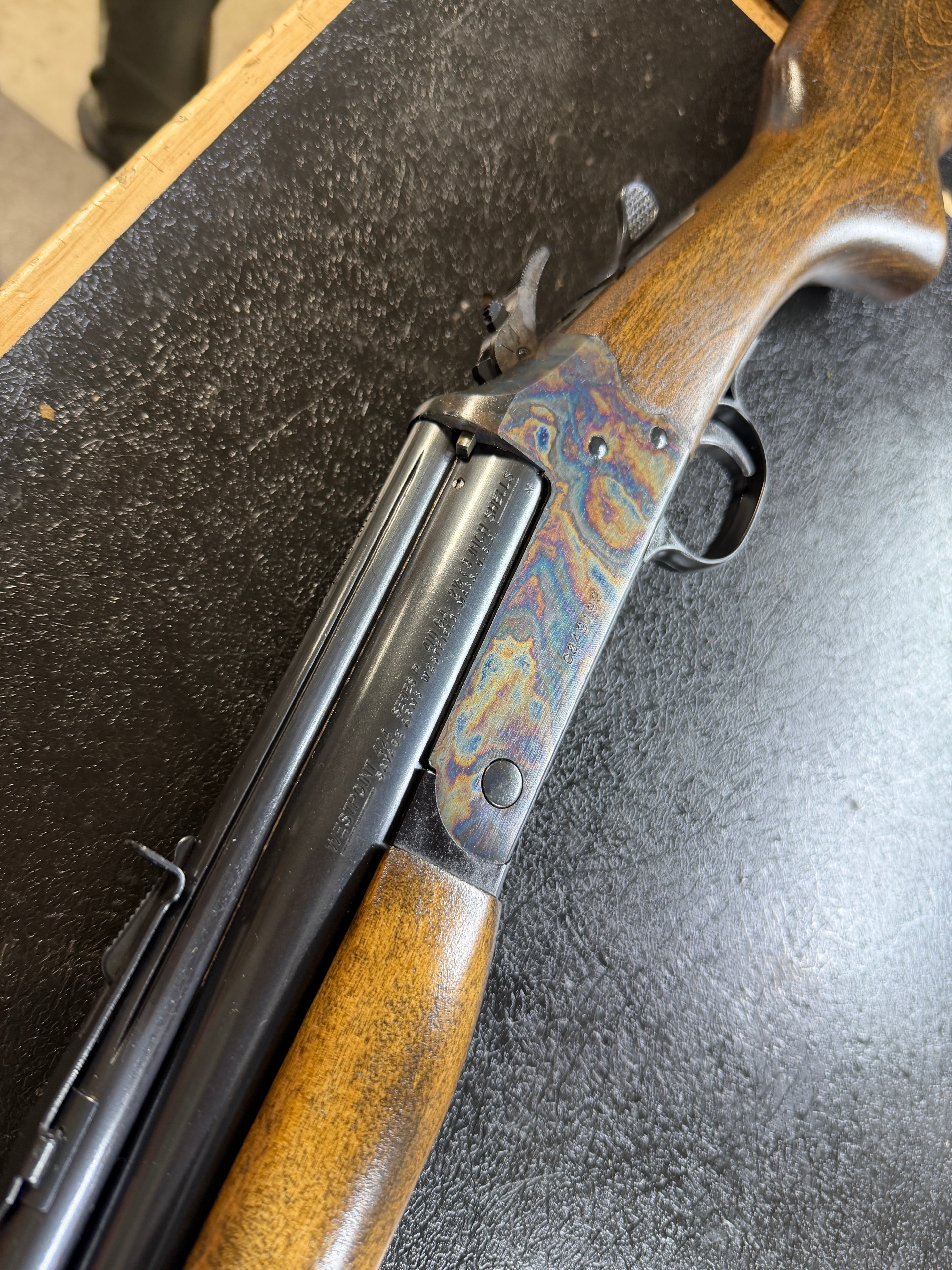 Case-hardened receiver with vivid color case hardening — swirling blues, purples, and ambers on restored pump-action shotgun receiver — by Northwoods Firearms, Crandon, WI