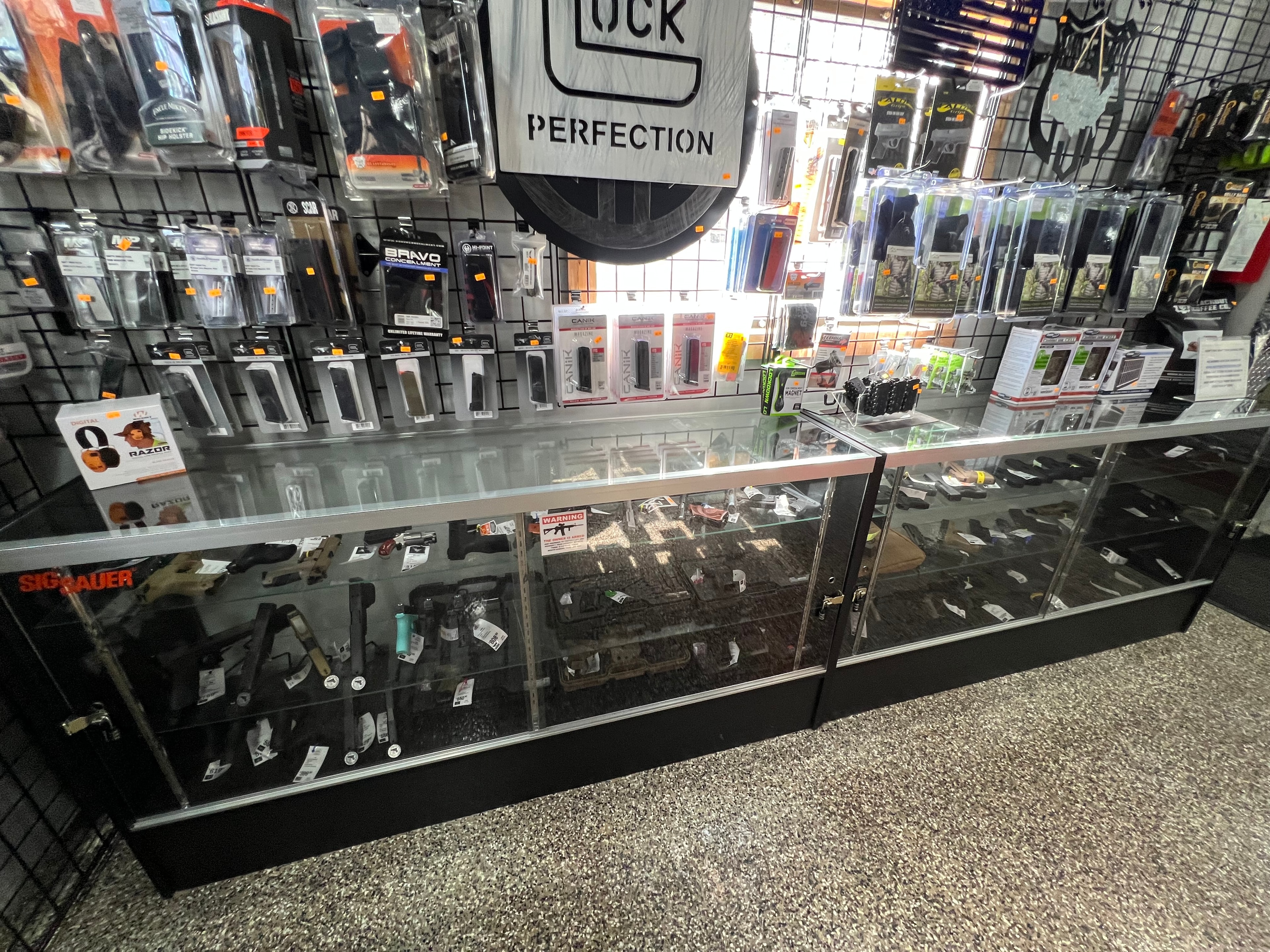 Northwoods Firearms handgun display case — Glock, Sig Sauer, Canik pistols with holster wall behind