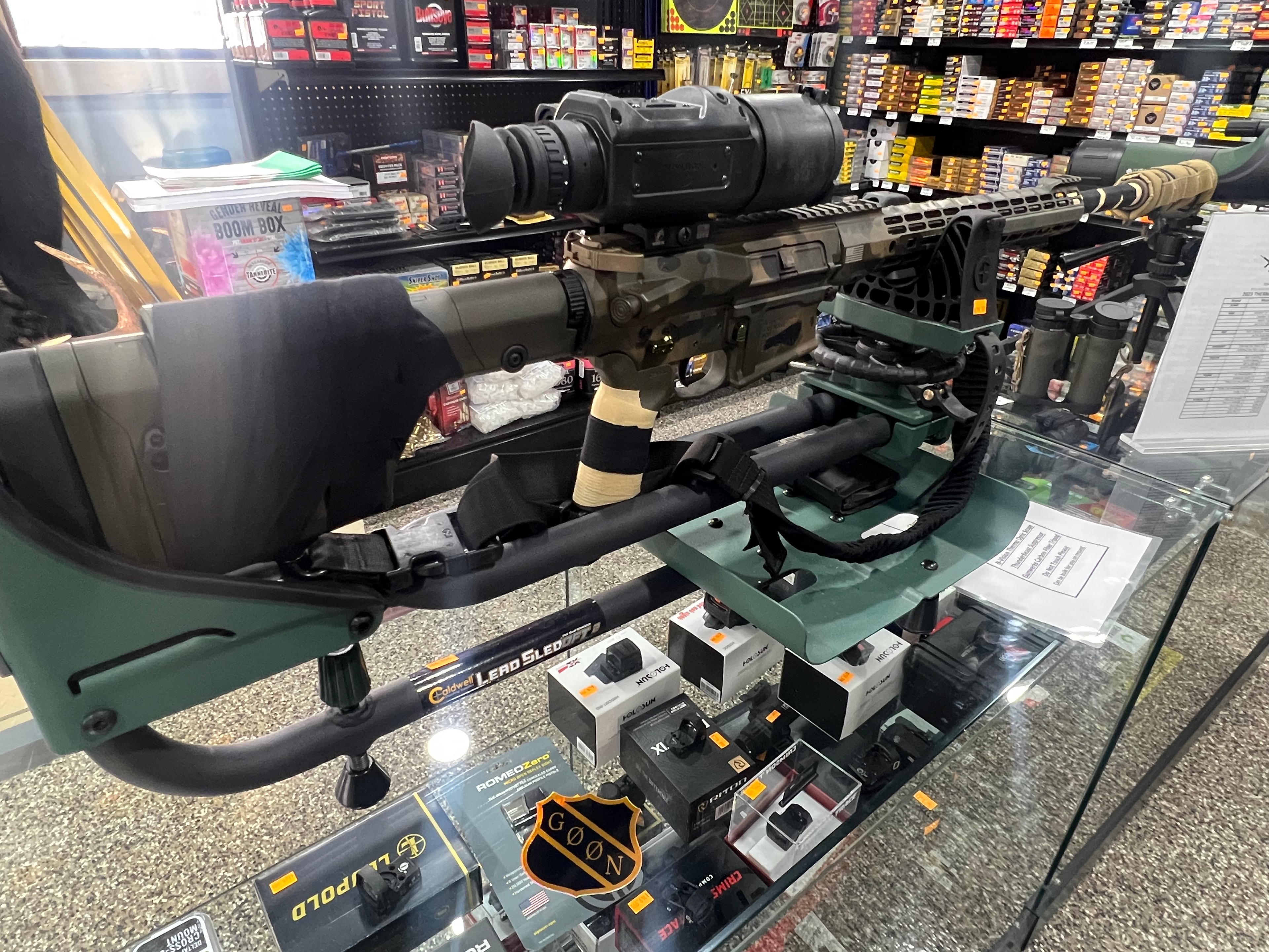 Northwoods Firearms precision rifle on display — custom build with thermal optic, bipod, and suppressor on glass counter