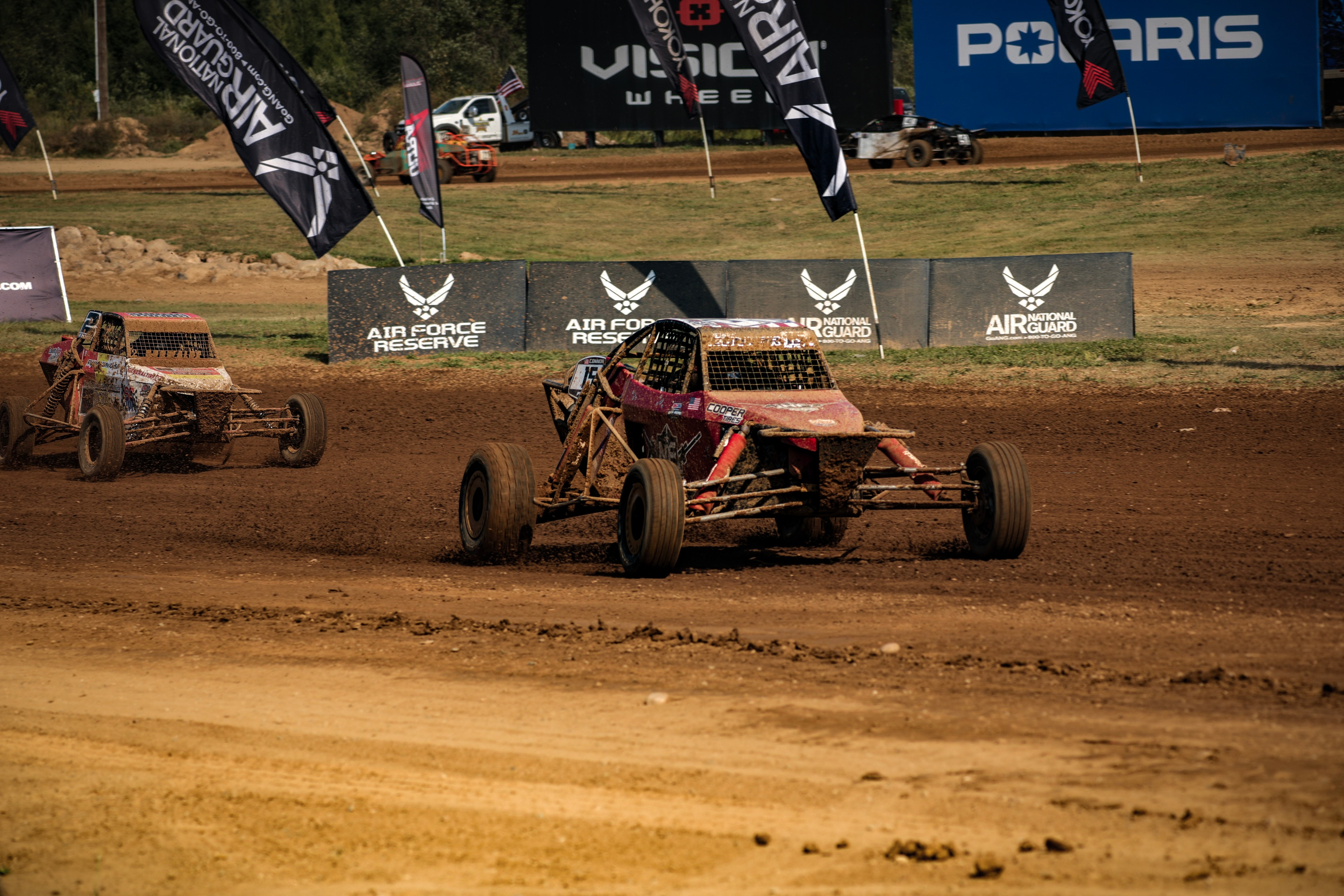 Connor #15 Northwoods Firearms Pro Buggy cornering hard past Air Force Reserve and Air National Guard barriers — Championship Off-Road Series